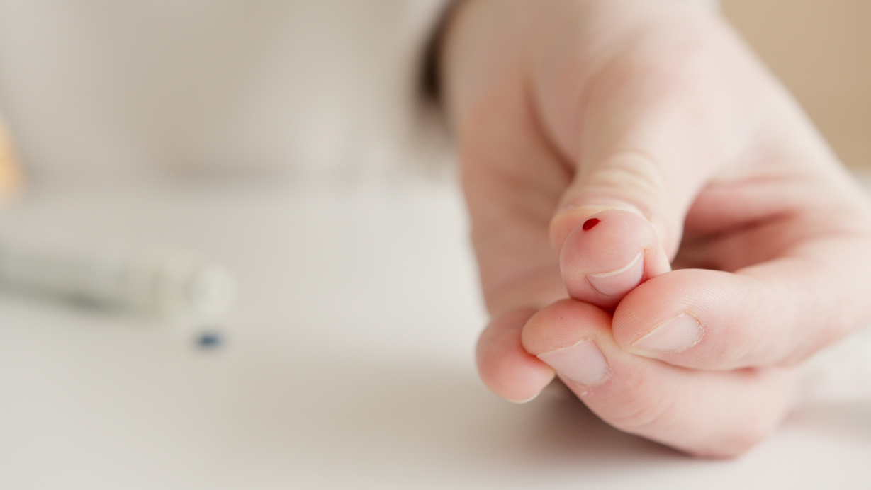 Person With Tiny Blood On Finger After A Blood Test